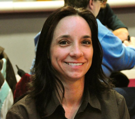 An up-close portrait of a smiling woman with short brown hair