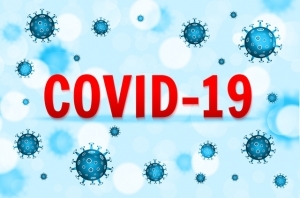 A digital illustration of blue viruses floating on a blue background. Covid-19 is centered in the middle in bold red letters. 