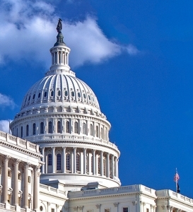 Photo of the dome of the senate building from below framed in blue sky.