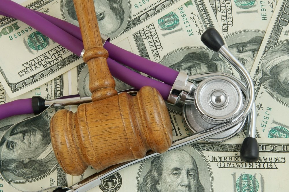 gavel and stethoscope on a pile of money