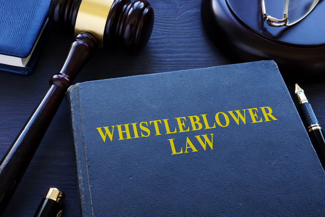 Whistleblower law book and gavel in a court.