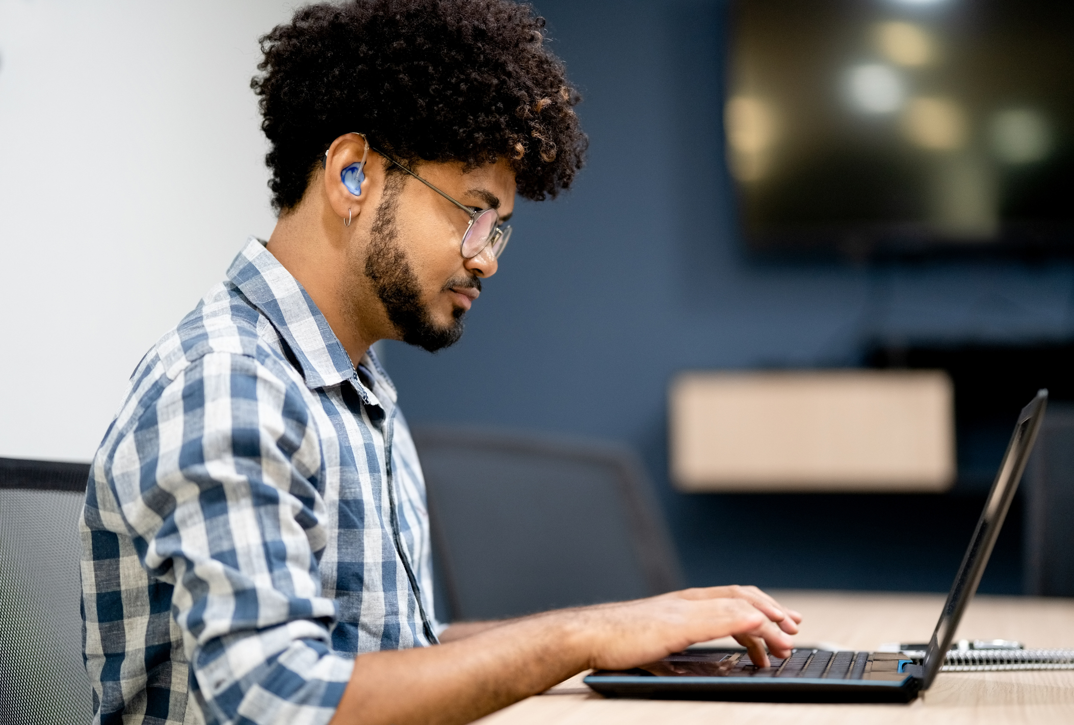 Hearing impaired man working on laptop at office