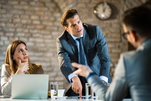 angry man arguing with his colleagues in the office